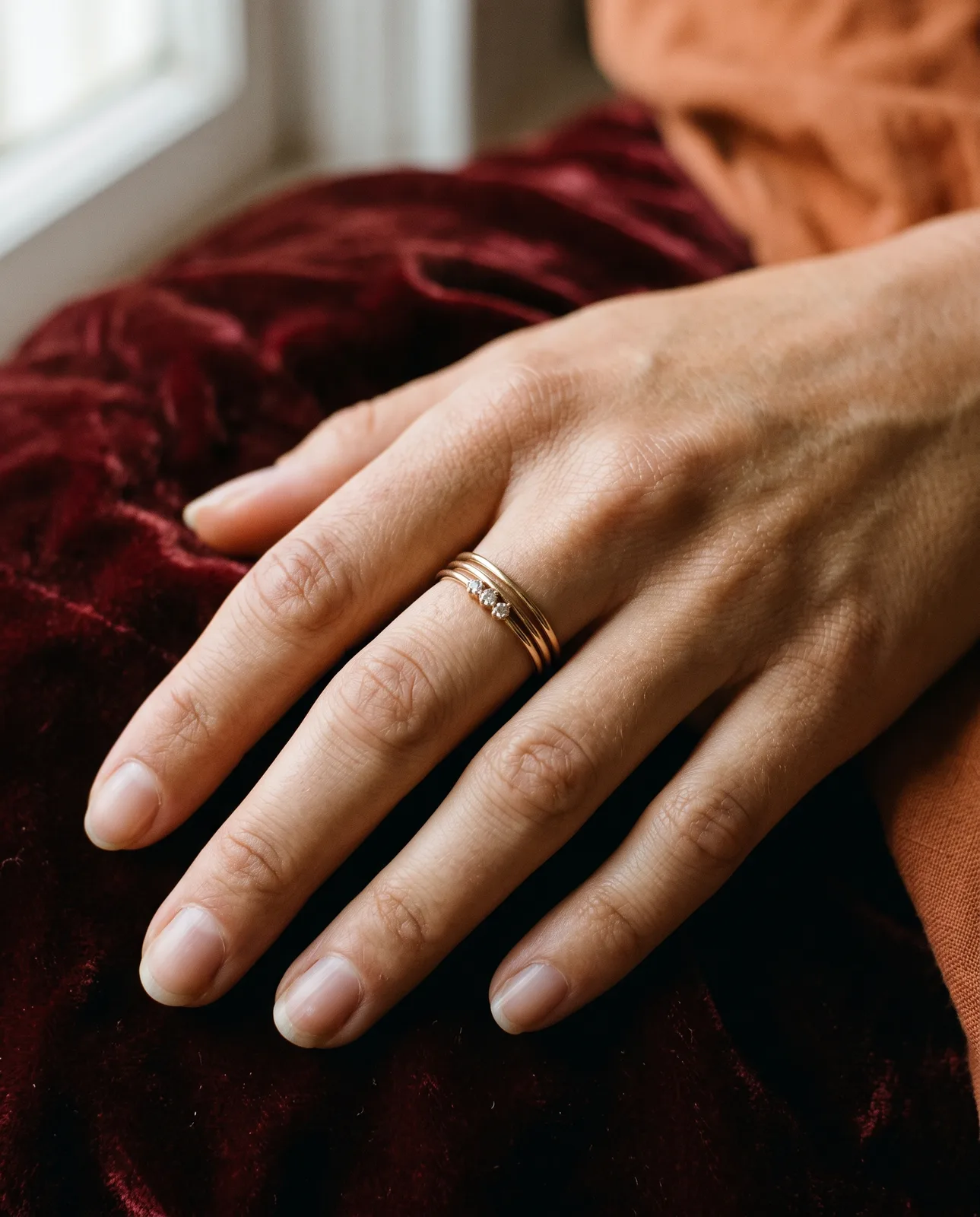 Three slim gold stacking bands worn together on one finger