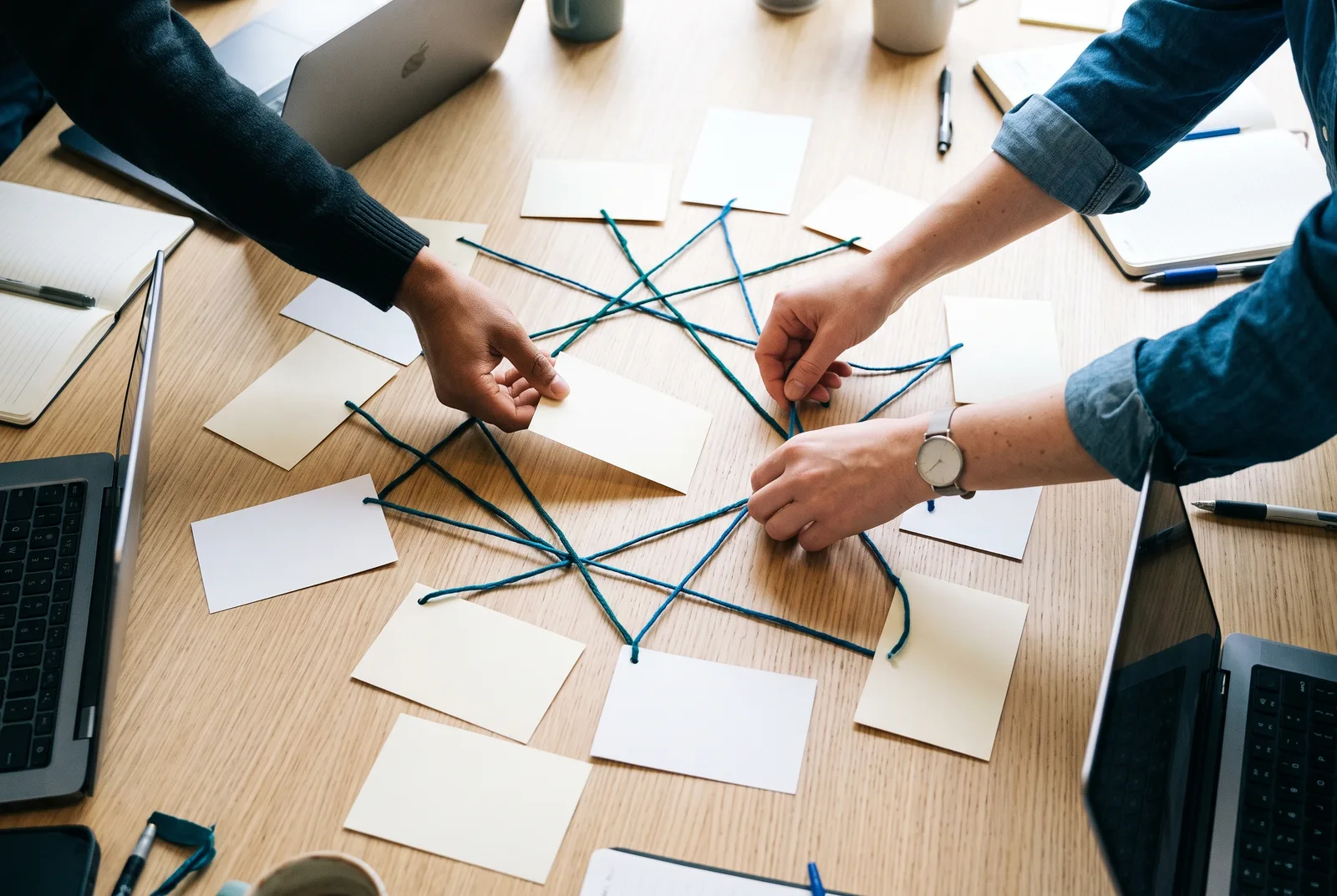 Engineers arranging cards on a table to map a system