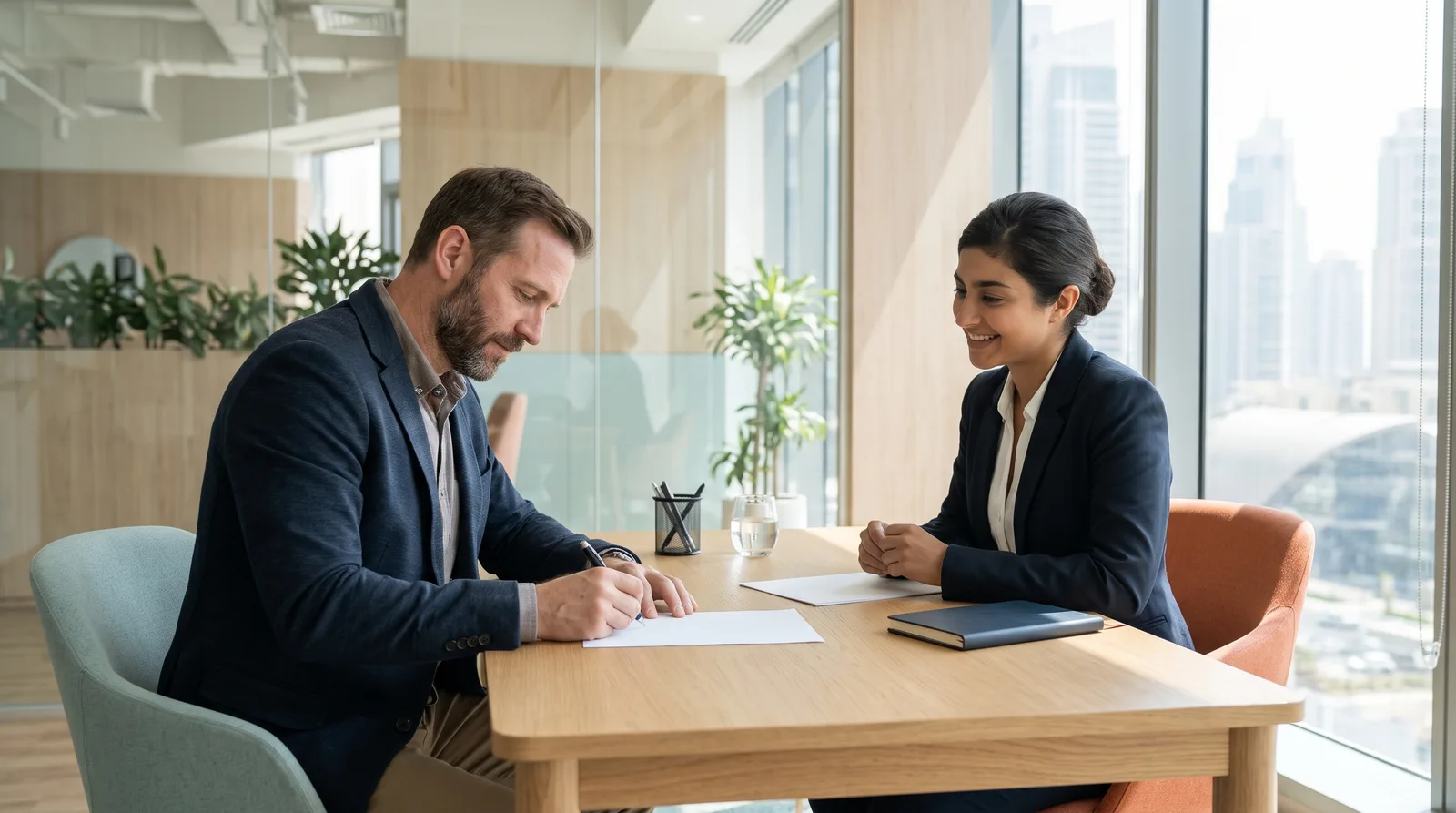 A business owner signing account forms across a desk from a relationship manager